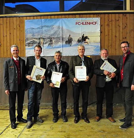 Un gruppo di sei uomini in posa con certificati davanti a un pannello di legno con un poster di cavalli sullo sfondo in un ambiente coperto.