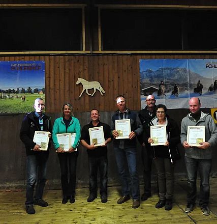 Gruppo di persone in piedi in una sala, ciascuna con un certificato in mano. Sfondo con immagini di paesaggi montani e un logo di cavallo.